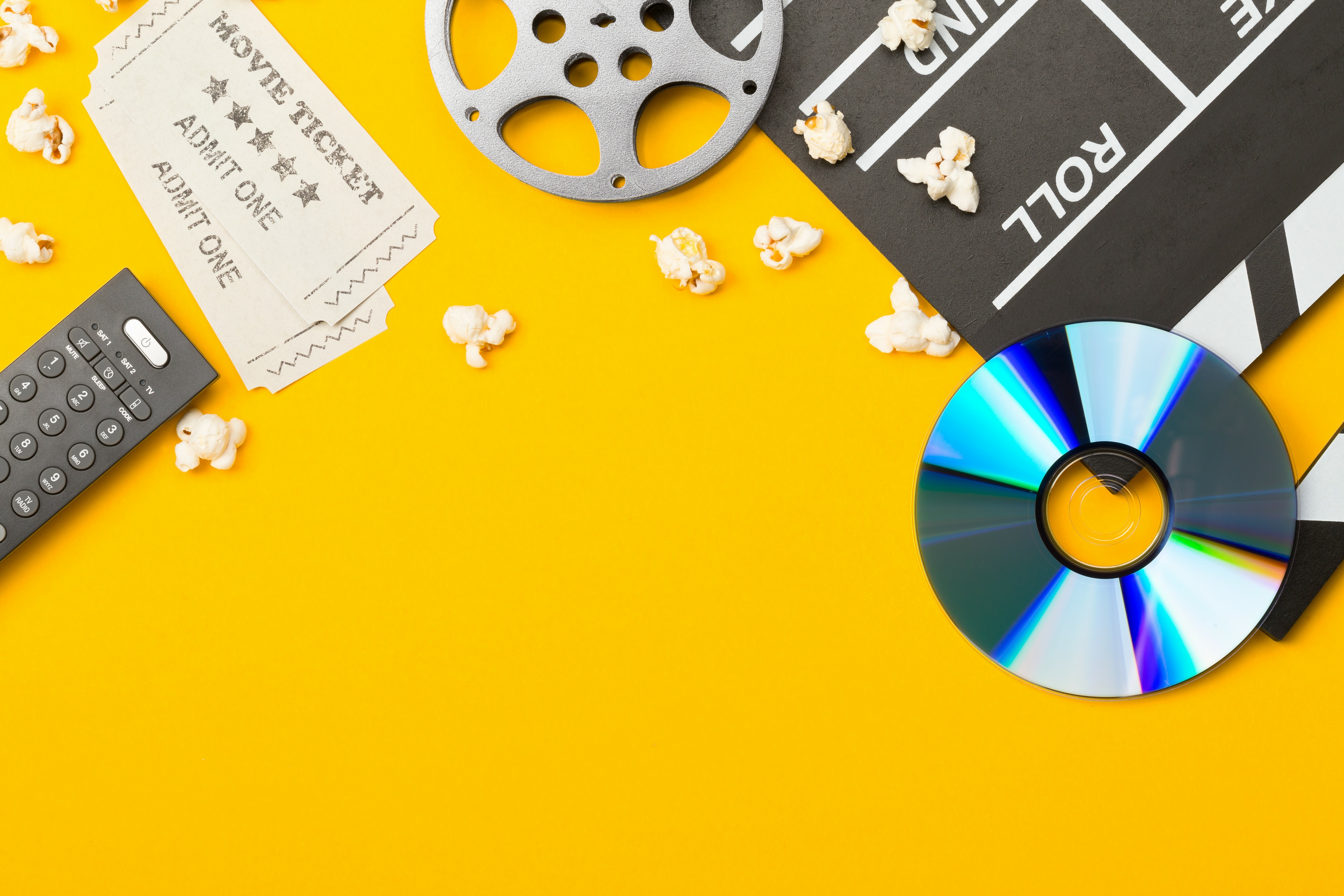 A composed scene of movie related items such as popcorn and DVDs.